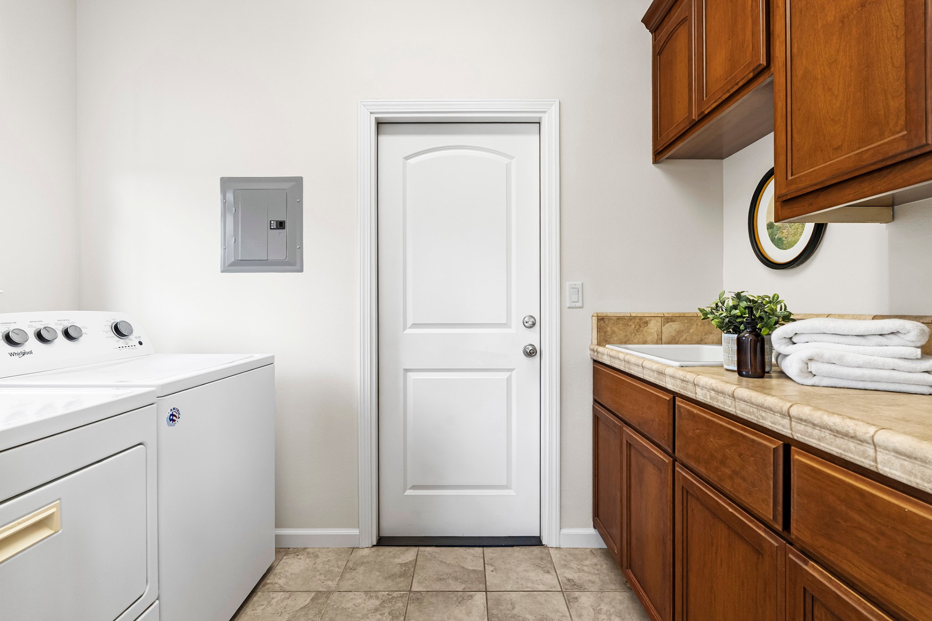 Laundry room with utility sink and cabinets